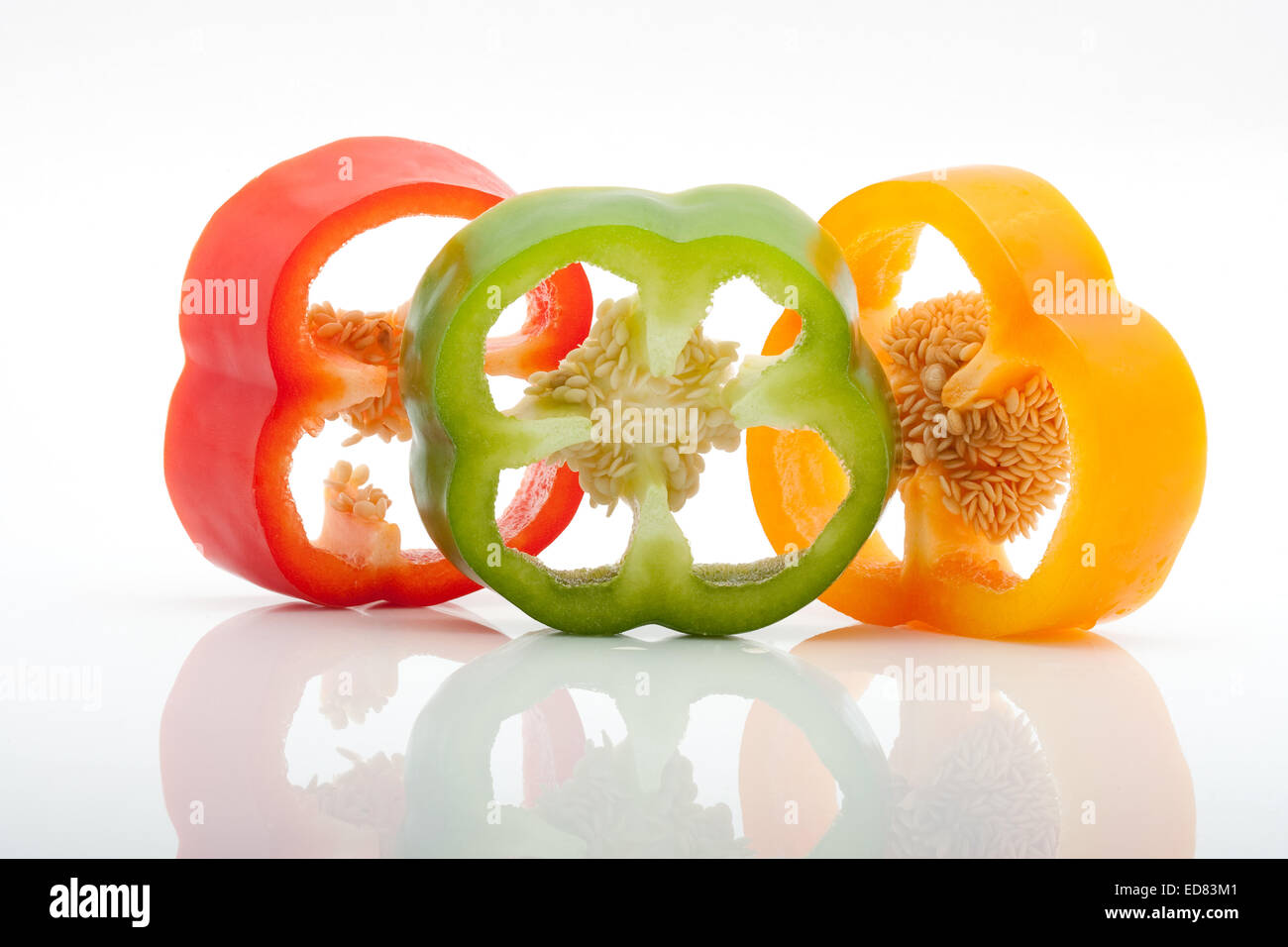 frisch geschnittene rote, grüne, gelbe und orange Paprika isoliert auf weißem Hintergrund Stockfoto