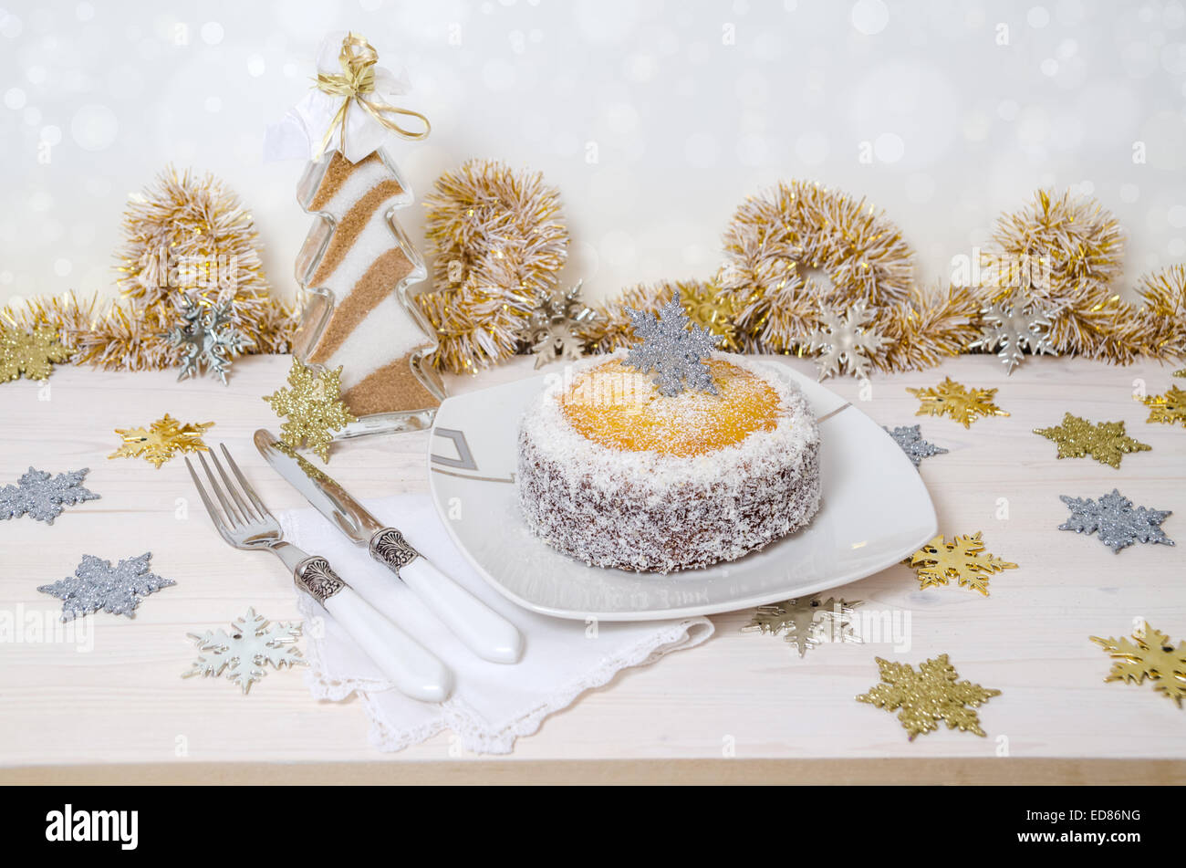 Festliche Kürbis-Kuchen mit Kokos auf Tisch und Weihnachtsdekoration. Hintergrund Bokeh. Reihe von Winter-Gebäck Stockfoto