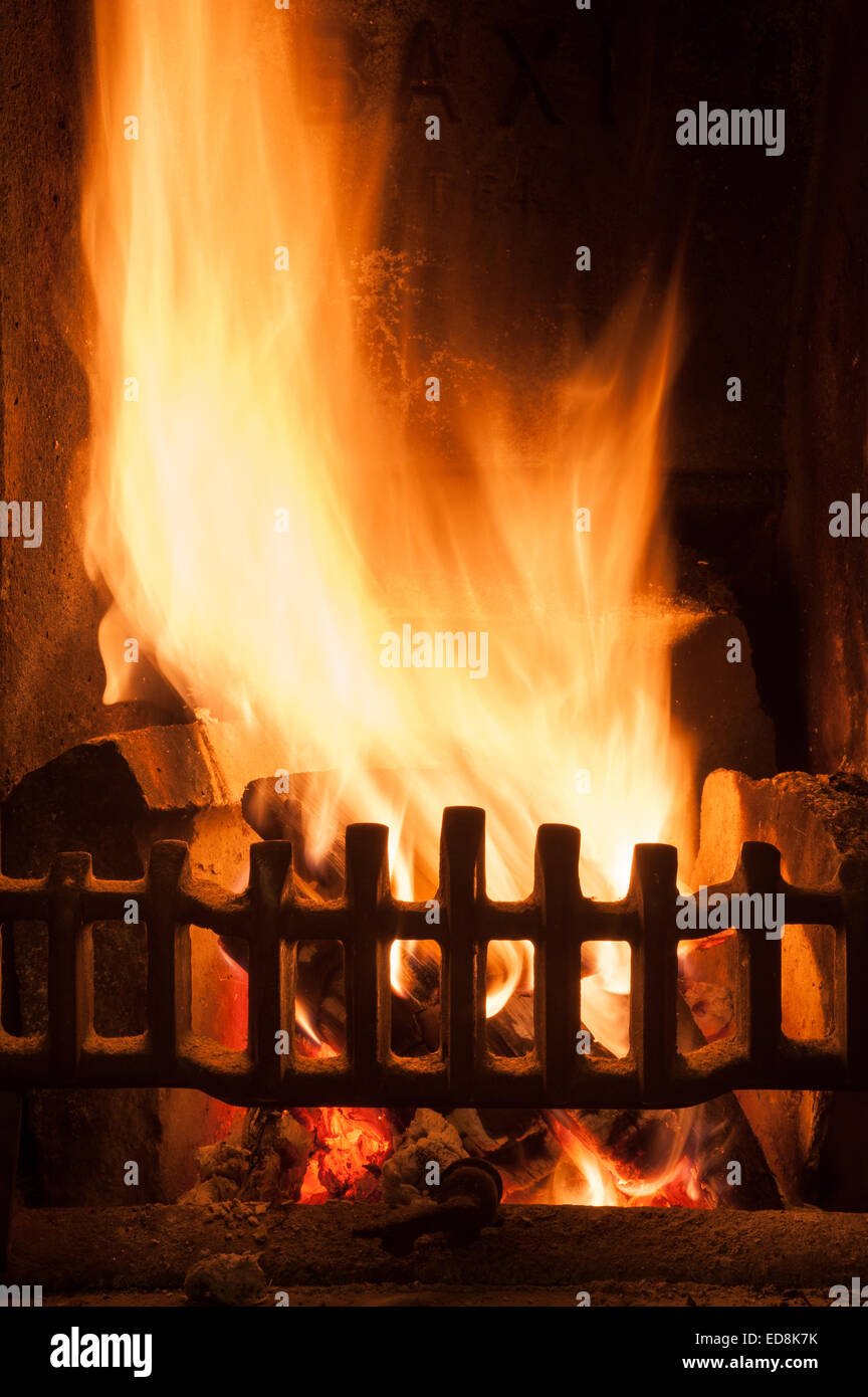 Herzlich Leuchten einer traditionellen Winter-Szene wie am offene Feuer in einem Haus leuchtende Licht strahlt, wie Holz Glut und Kohle heiß verbrennen Stockfoto