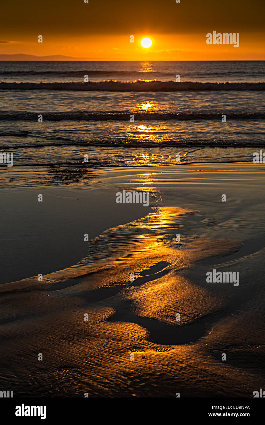 Reflexionen des Sonnenuntergangs im Sand am Strand, Southerndown, Glamorgan, Wales, UK Stockfoto