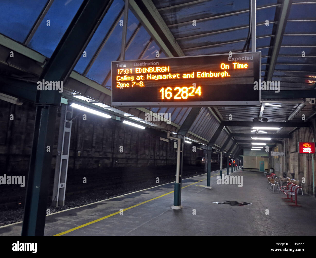 Leerer Bahnsteig an der Carlisle Station, Cumbria in der Dämmerung, Anzeige zeigt WCML Avanti Zug nach Edinburgh Stockfoto