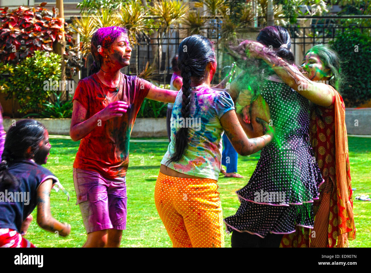 Gruppe von jungen Mädchen spielen mit Pulver Farben & Wasser während das hinduistische Frühlingsfest Holi auch bekannt als ein Fest der Farben Stockfoto