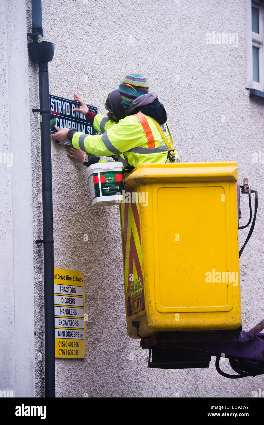 Zwei lokale Behörde (Ceredigion County Council) direkte Arbeitskräfte beschäftigten Arbeitnehmer in eine "Cherry-Picker" ersetzt die Zeichen auf der Cambrian Street, Aberystwyth, mit neuen Versionen mit "Erbe" Schrift, Wales UK Stockfoto