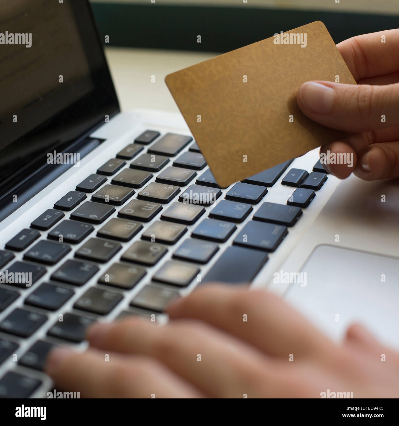 Kreditkarte (mit Platz für Ihren Text) in der Hand und Eingabe Sicherheitscode mit Laptop-Tastatur. Stockfoto