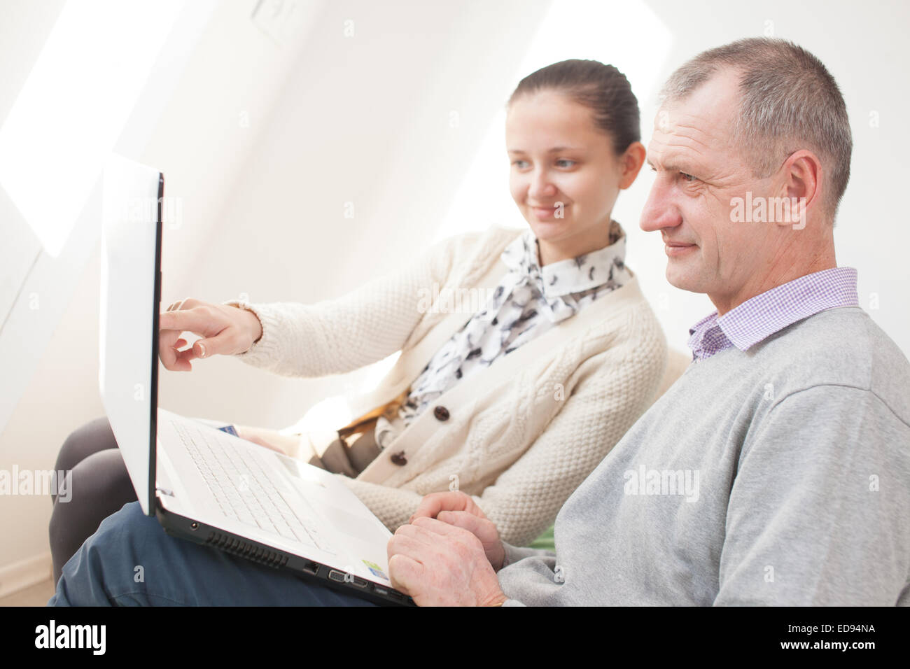Mädchen Unterricht Verwendung eines Laptops von älteren Mann Stockfoto