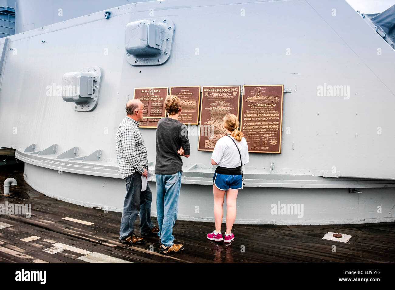 Ein Vater mit seinen Kindern lesen die Widmung Plaques auf einen Geschützturm des Schlachtschiffes USS Alabama befindet sich in der Gedenkstätte Par Stockfoto