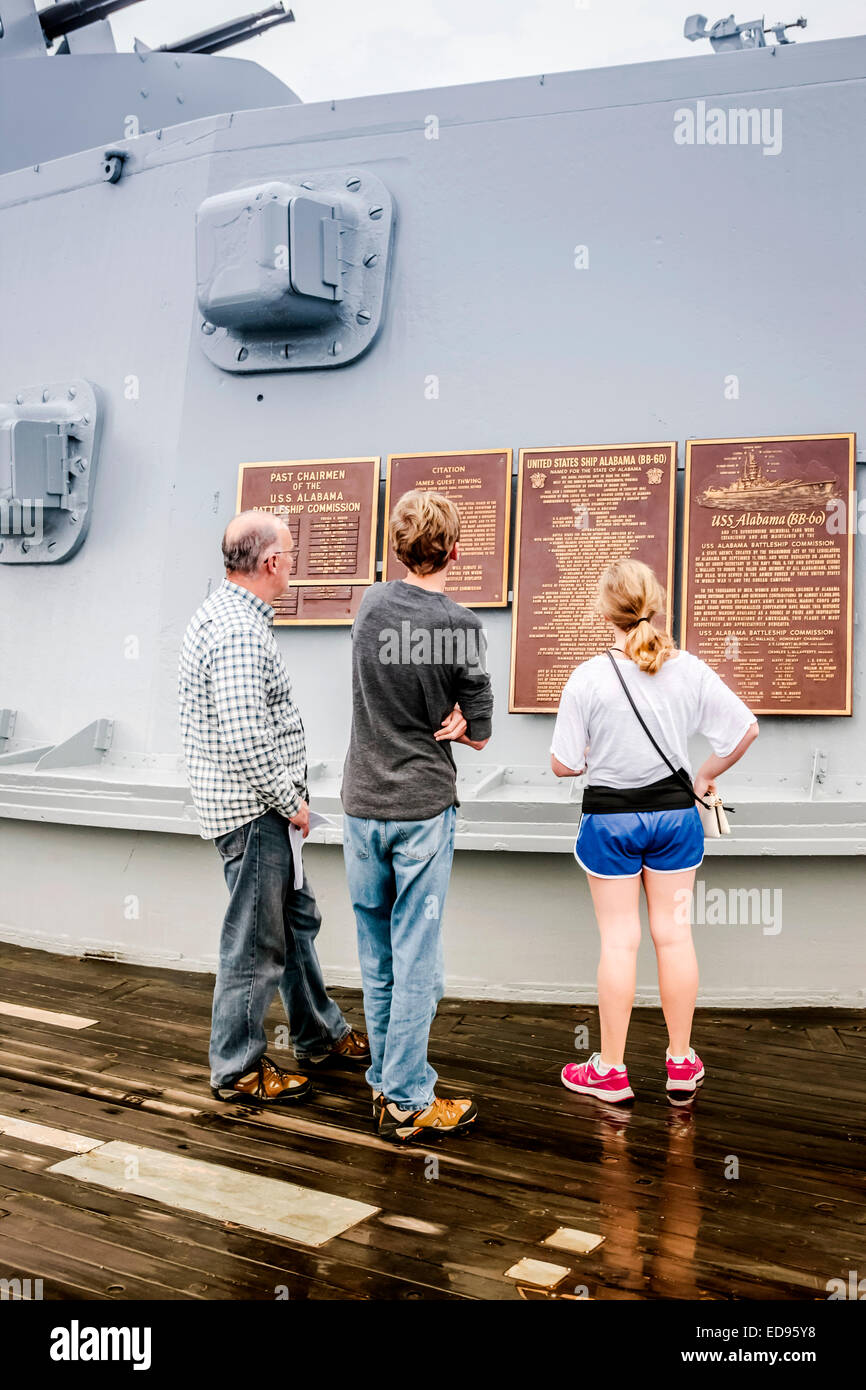 Ein Vater mit seinen Kindern lesen die Widmung Plaques auf einen Geschützturm des Schlachtschiffes USS Alabama befindet sich in der Gedenkstätte Par Stockfoto