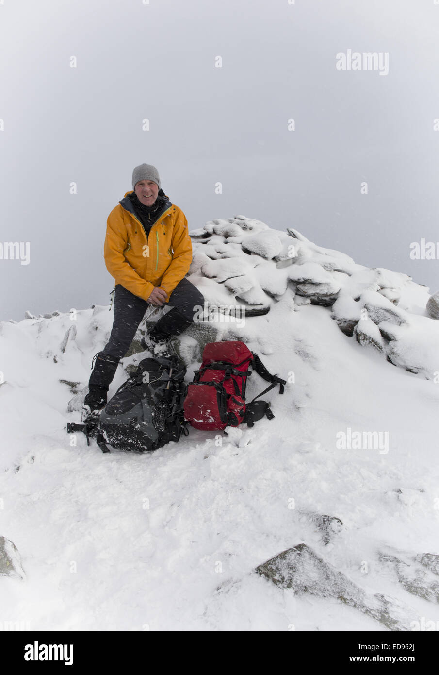 Winter-Bergsteiger auf Schnee bedeckt Gipfel cairn Stockfoto