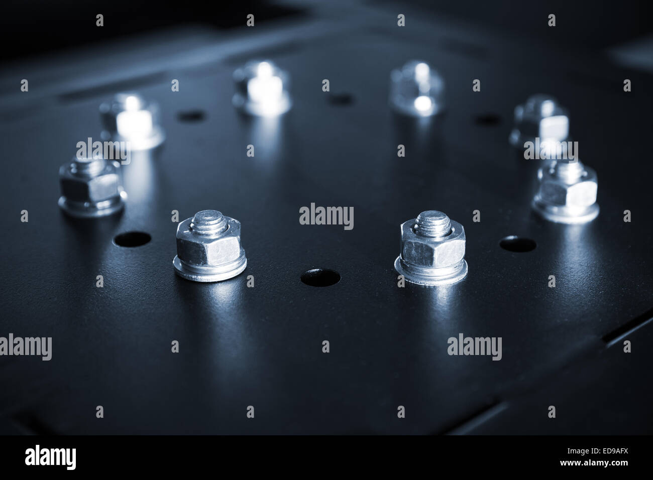 Glänzende Stahl Schrauben und Muttern in einem Kreis auf schwarzem industrielle cover Stockfoto