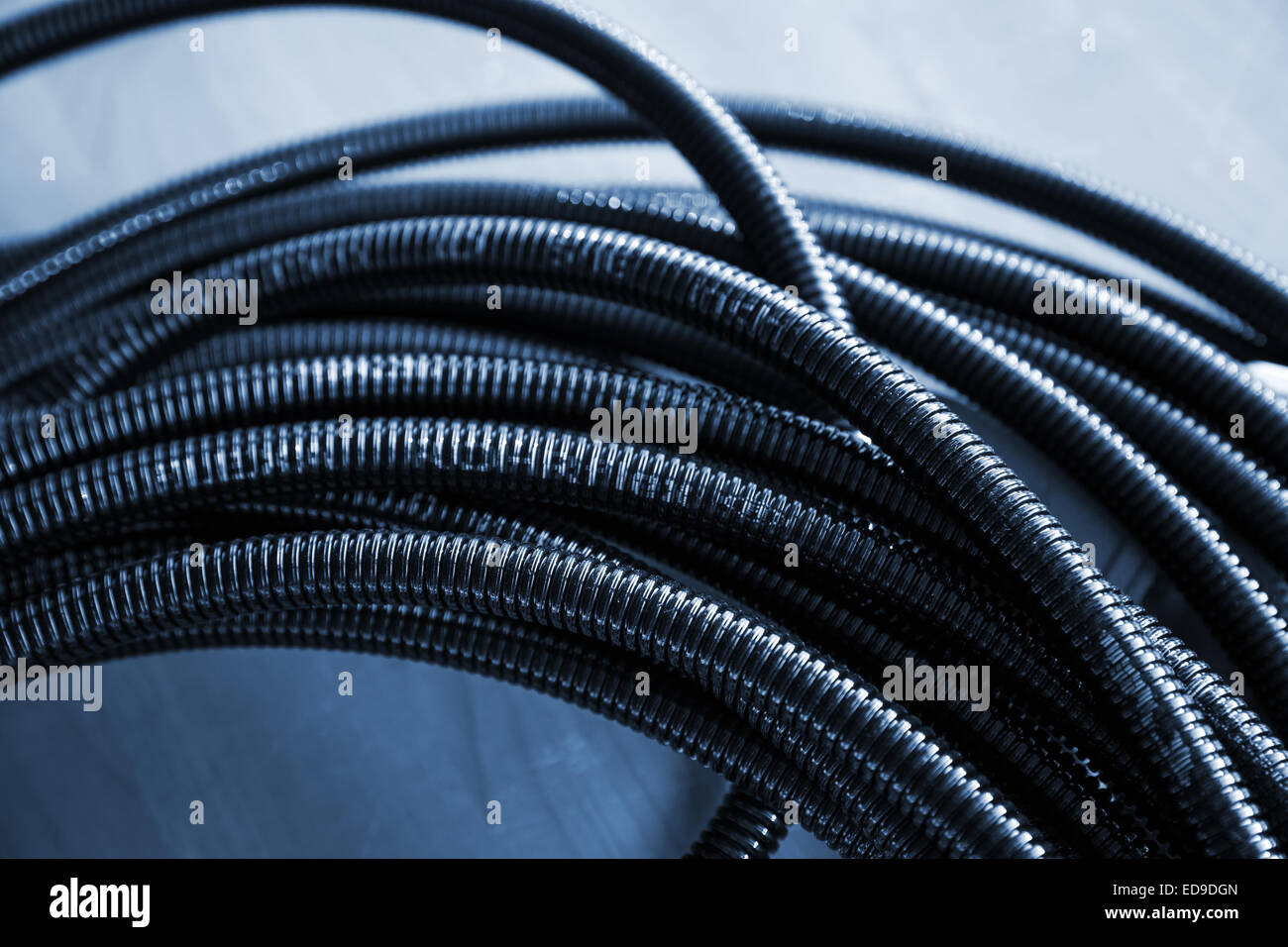 Bündel von schwarzen Kunststoff-Kabelkanal. Blau getönten Foto Stockfoto