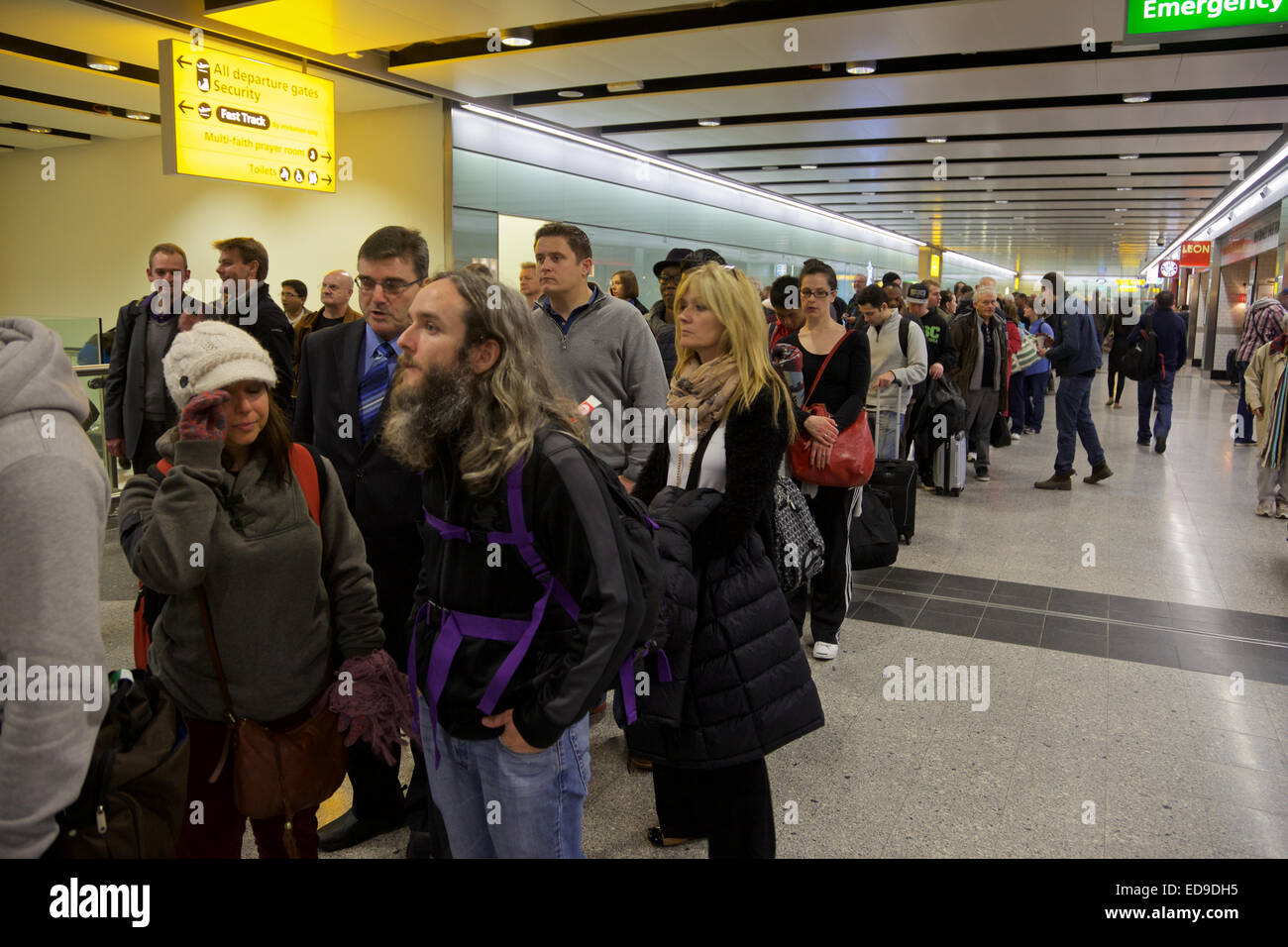 Passagiere, die Warteschlangen am Flughafen Heathrow, London Stockfoto