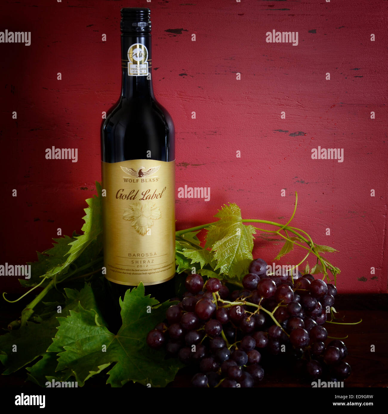 Australische Premium Export Qualitätswein mit Flaschen von Wolf Blass Gold und schwarz Etikett Wein auf dunkelroten Hintergrund Holz Stockfoto