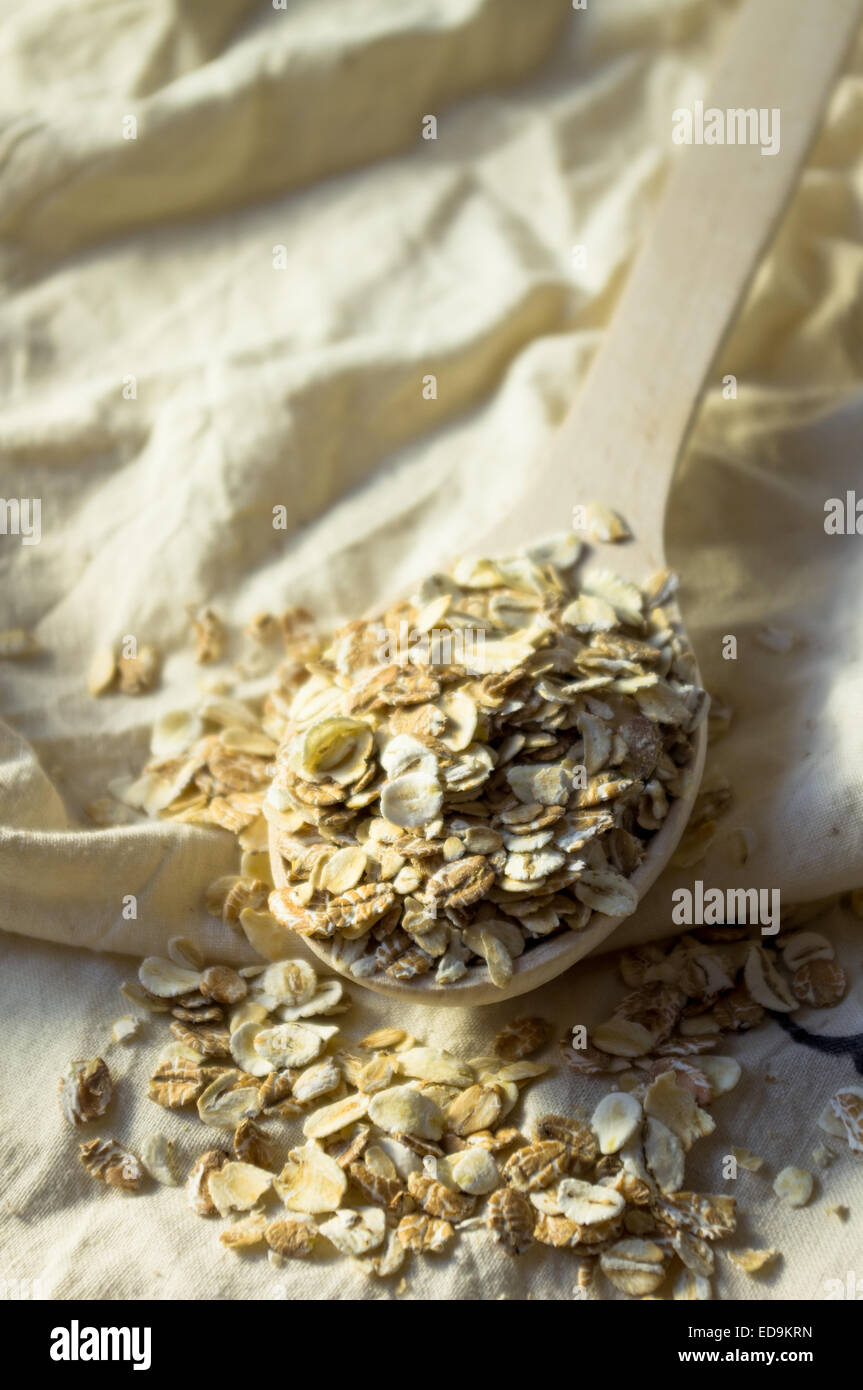 Haferflocken in einem Holzlöffel auf einem Stoff-Hintergrund Stockfoto
