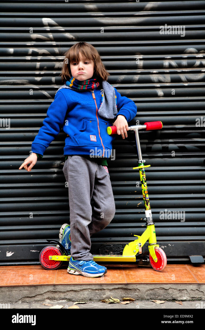 6-jährige posiert mit seinem Roller Grimasse. Stockfoto
