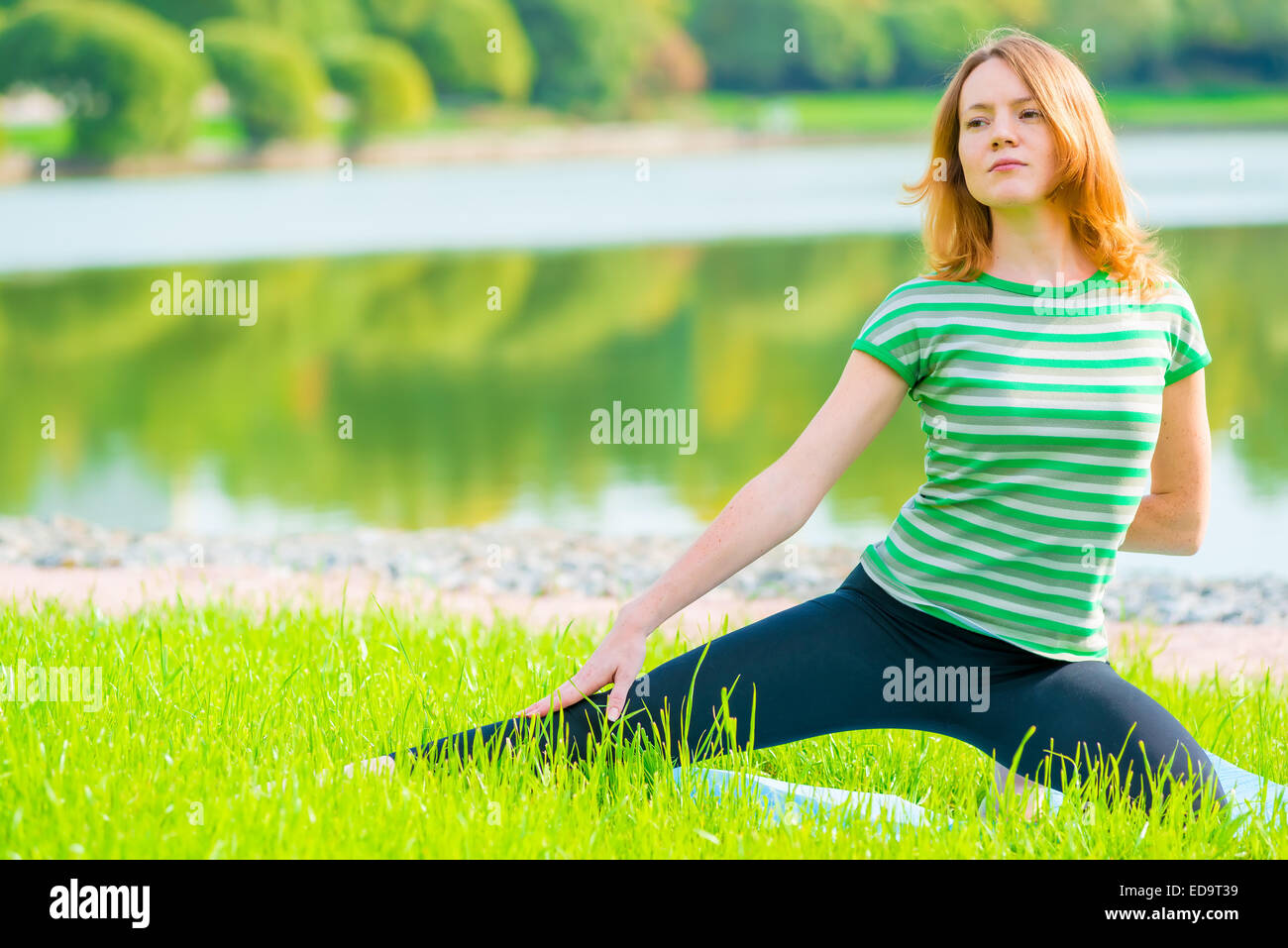 Sportlerinnen haben Übungen auf dem grünen Rasen im park Stockfoto