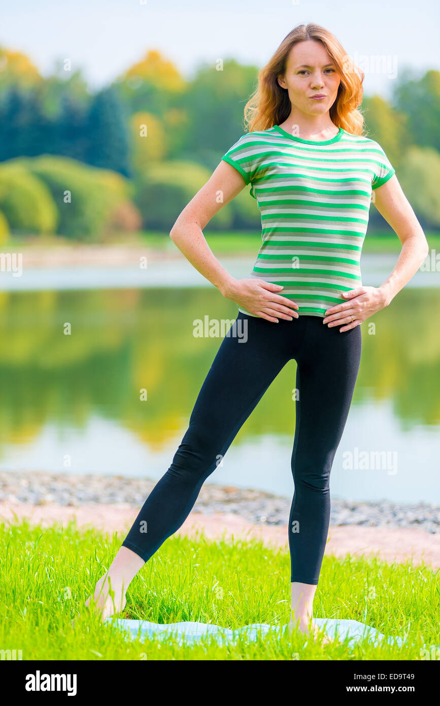 schlanke Sportler tun stretching Übungen Muskeln auf die Natur Stockfoto