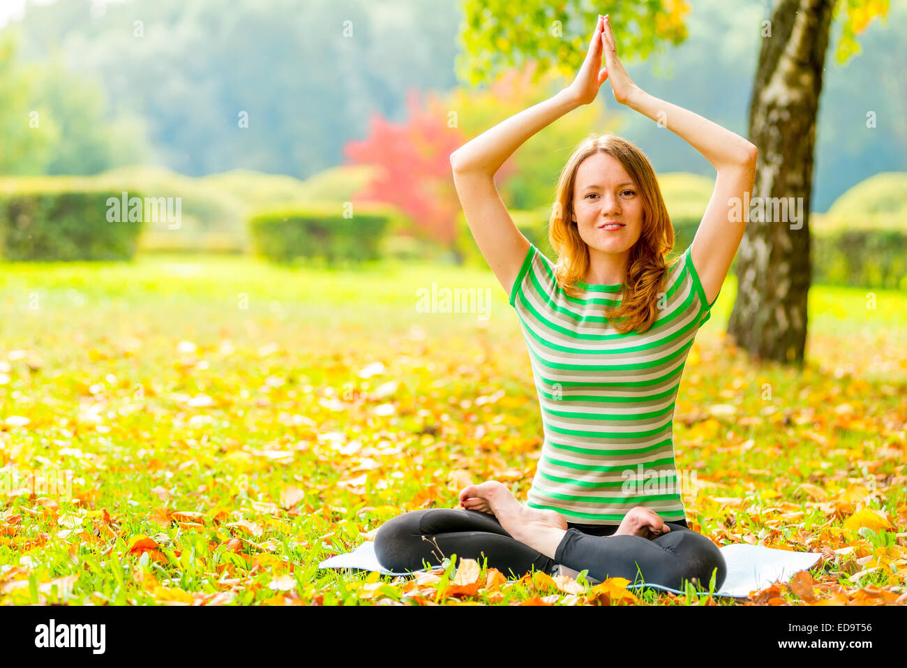 Mädchen in einem gestreiften T-shirt im Herbst Park Übungen Stockfoto