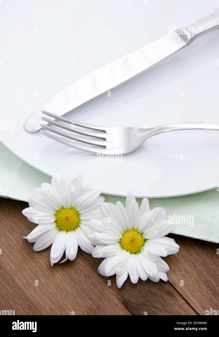 Besteck auf Teller mit Blumen auf Holztisch Stockfoto