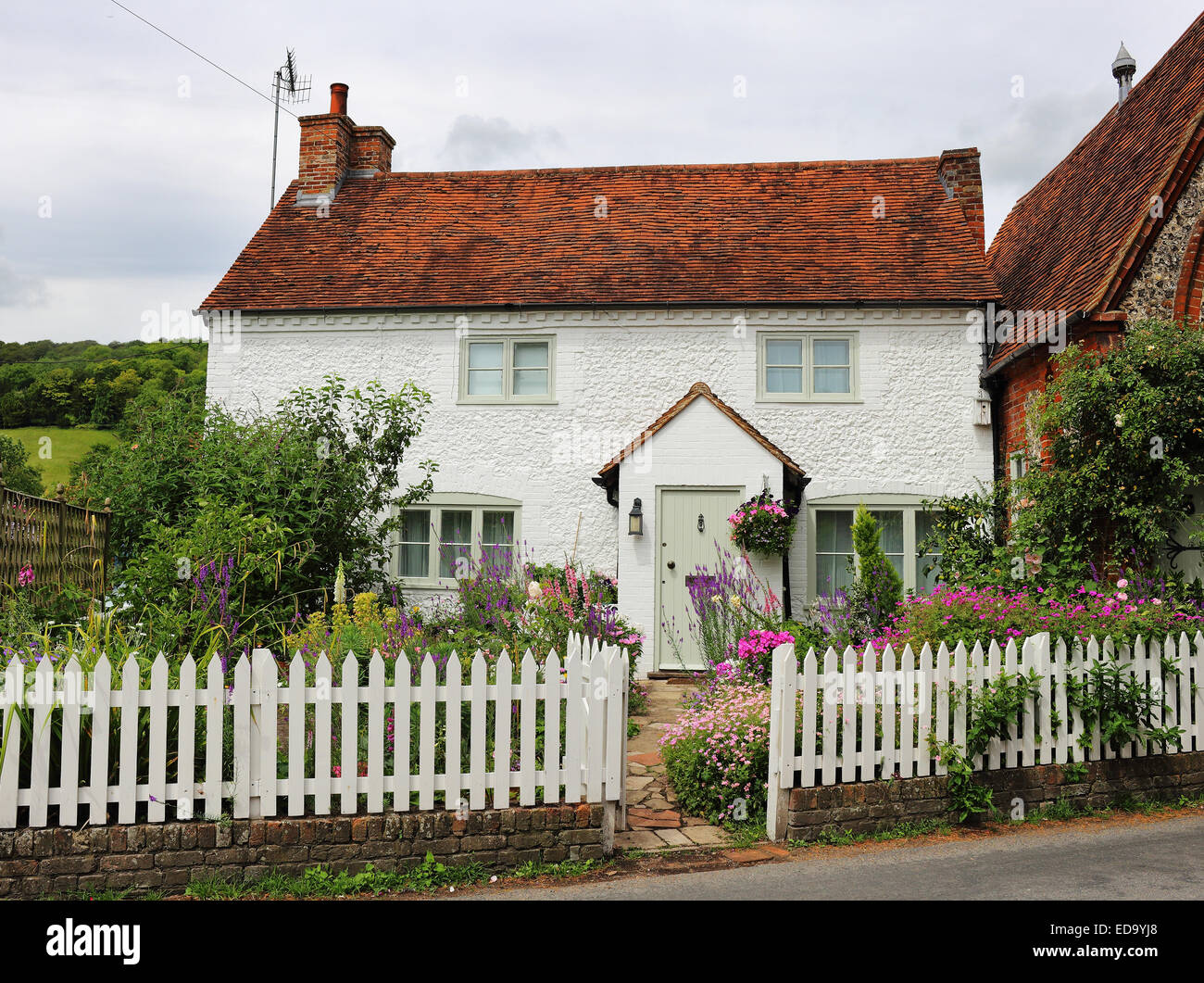 Traditionell weiß getünchten englischen Landhaus Stein und Garten mit Lattenzaun Stockfoto