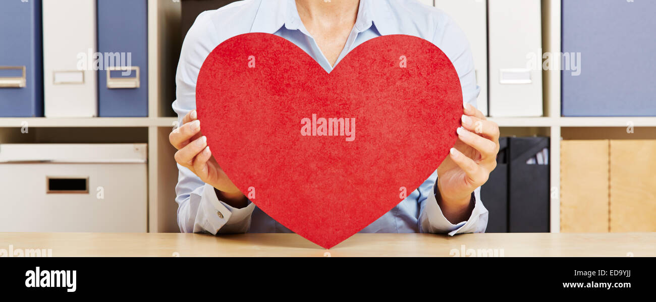 Panorama von zwei weiblichen Hände halten ein großes rotes Herz Stockfoto