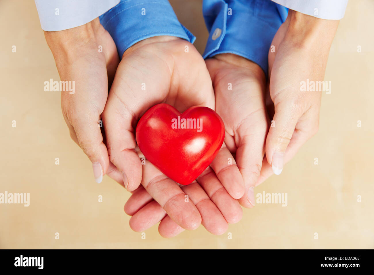 Händen der ein Liebespaar halten zusammen ein rotes Herz Stockfoto