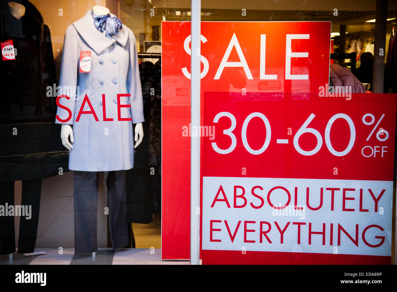 Großer Verkauf Zeichen Poster in einem Schaufenster zeigen Kleidung zum Verkauf, Merry Hill Shopping Center, West Midlands, UK Stockfoto
