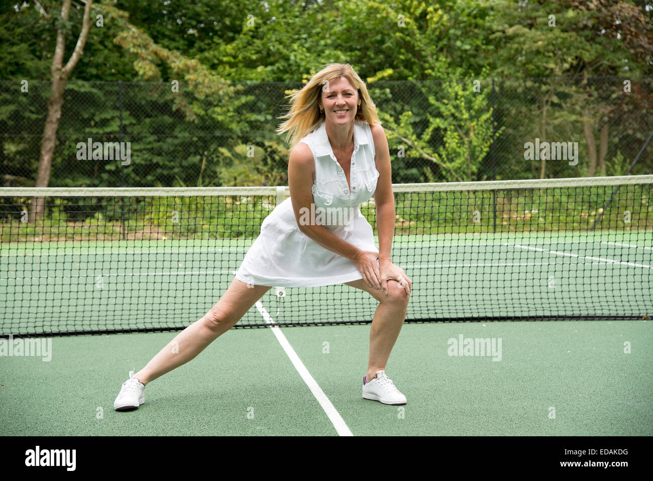 Sportlerin Lockerungsübungen bis auf ein Tennis Court gesunde Bewegung und halten Sie sich fit Stockfoto