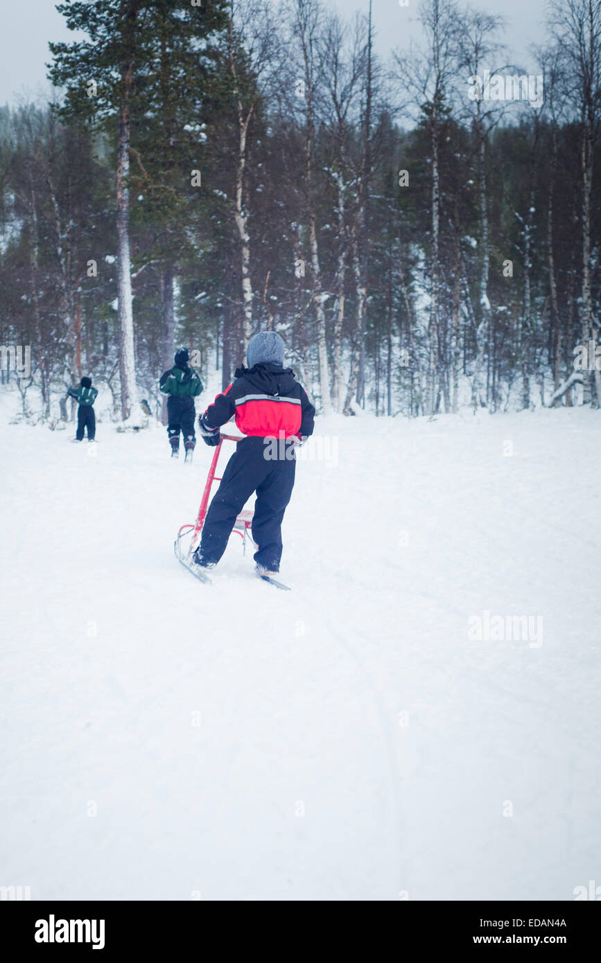 Jungen, die Spaß am Kick Schlitten in Lappland Stockfoto