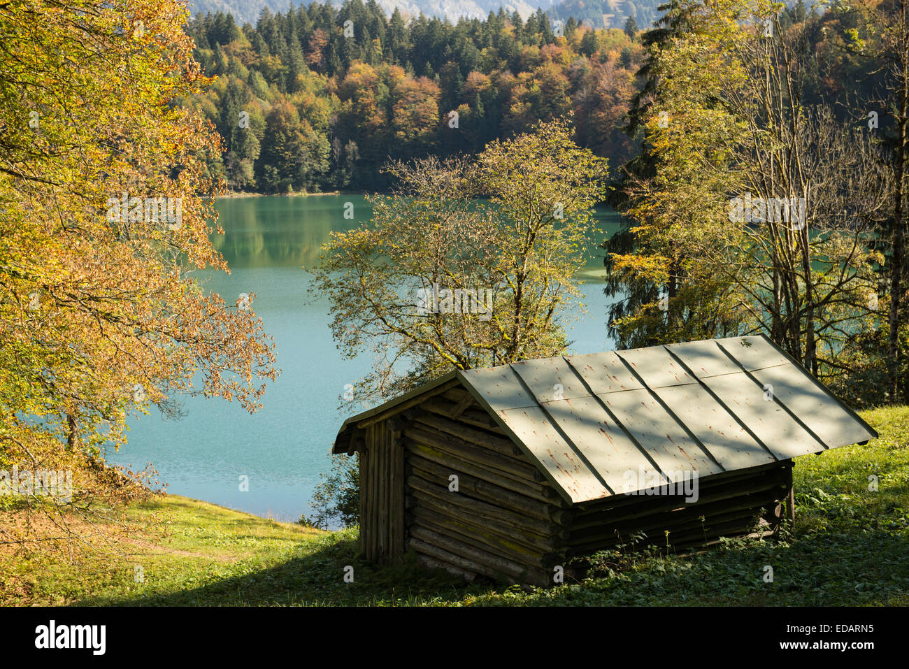 Holzhütte im Herbst an einem türkisfarbenen See Stockfoto