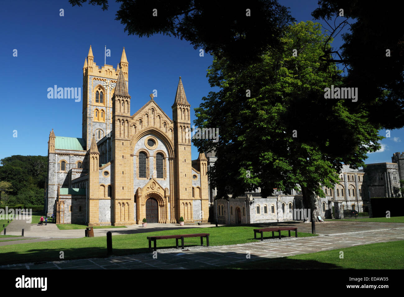 Eine große Abtei aus goldenen Stein mit einem Turm gebaut und von Wiesen umgeben. Stockfoto