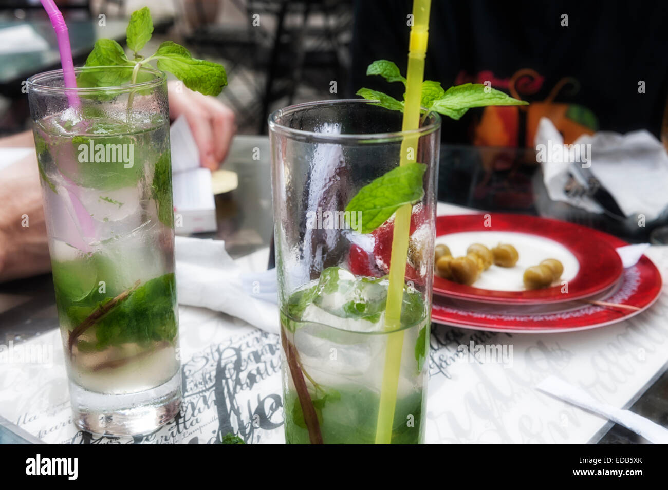 Café La Lamparilla downtown Havanna, mit zwei hohe Gläser Mojitos und Oliven während touristische Buch liest. Entspannung, ferienhäuser, Cocktail rum Essen trinken. Stockfoto