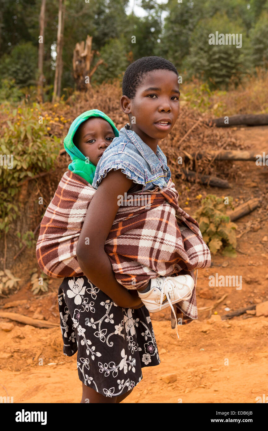 HHOHHO, Swasiland, Afrika - junges Mädchen trägt ihren Bruder auf dem Rücken Stockfoto