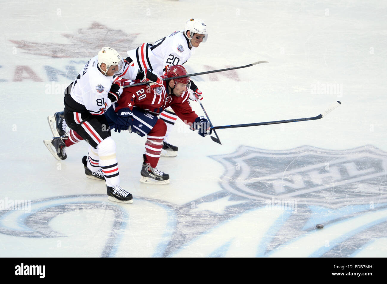 Washington ist Troy Brouwer, zentrieren, wird aus einem Puck Chase von Chicagos Marian Hossa, drückte vorne und Brandon Saad während 2015 Winter Classic Professional Eishockeyturnier am Nationals Park 1. Januar 2015 in Washington D.C. Brouwer erzielte den Siegtreffer mit 12,9 Sekunden auf der Uhr zu den Chicago Blackhawks 3-2 schlagen. Stockfoto