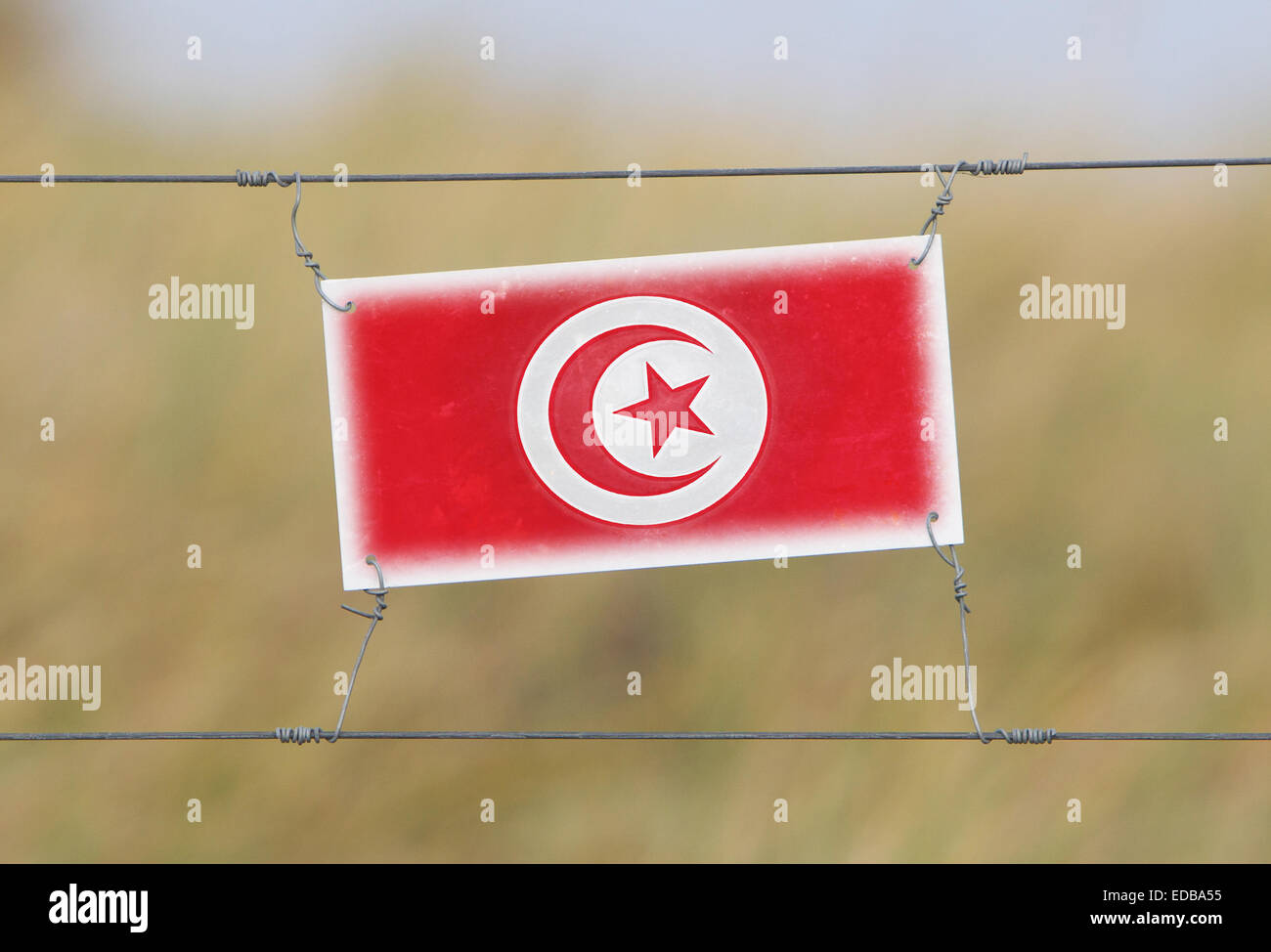 Grenze Zaun - alte Kunststoffschild mit einer Fahne - Tunesien Stockfoto