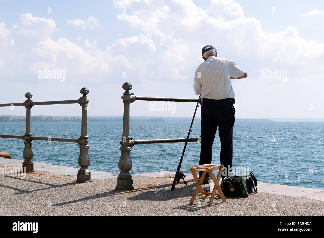 Ein Alter Mann entspannt sich mit der Fischerei auf dem dock Stockfoto