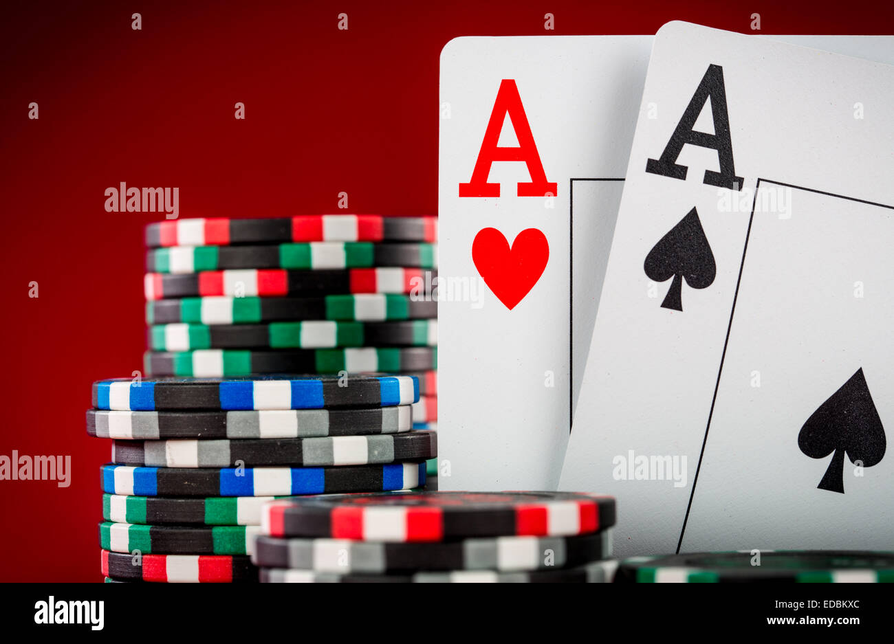Stapel Chips und zwei Asse auf dem Tisch auf den roten Filz - Poker-Spiel-Konzept Stockfoto