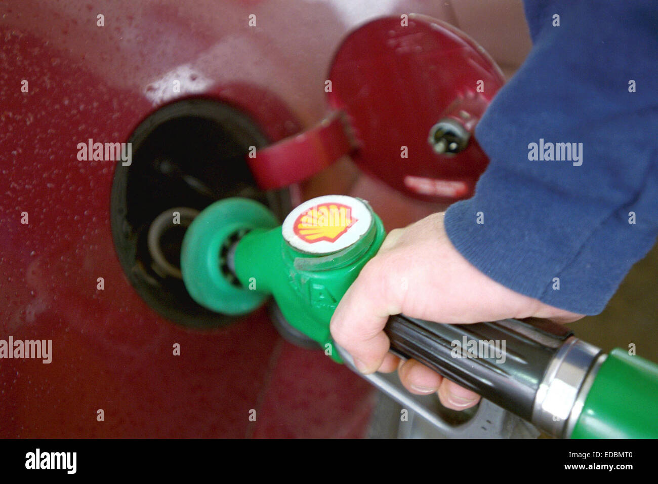 ein Mann füllt sich sein Auto an einer Shell-Tankstelle Benzin. Stockfoto