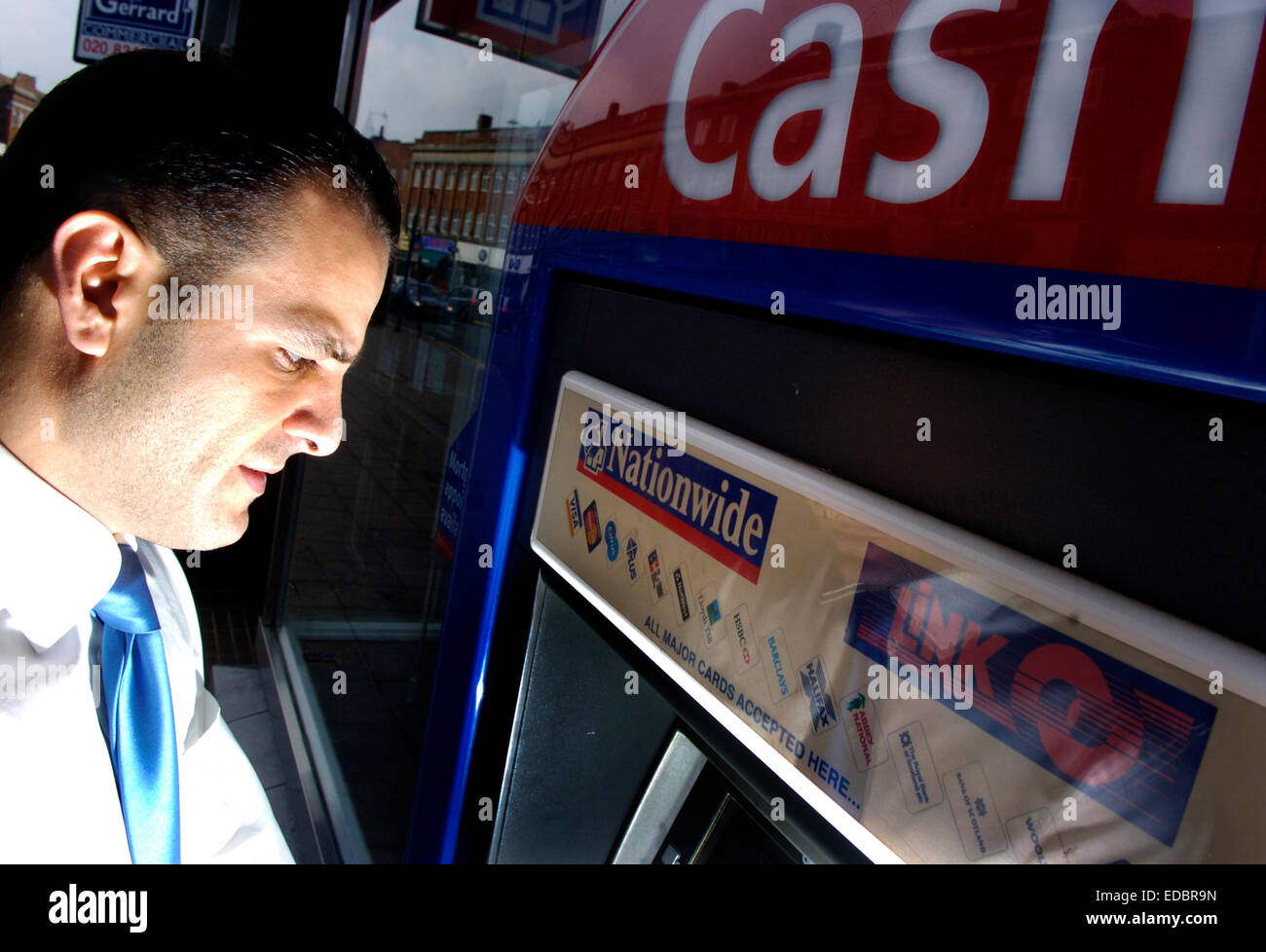 Ein Mann mit einem bundesweit Geldautomaten. Stockfoto