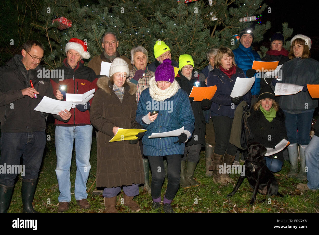 Einheimische im Freien singen Weihnachtslieder Weihnachten in ihrem Dorf, Dockenfield, in der Nähe von Farnham, Surrey, UK. Stockfoto
