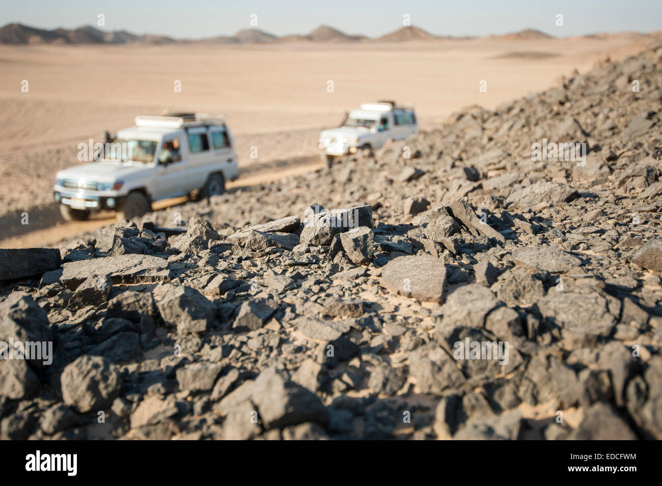 Zwei Geländewagen fahren durch eine desolate trockenen steinigen Wüstenlandschaft Stockfoto