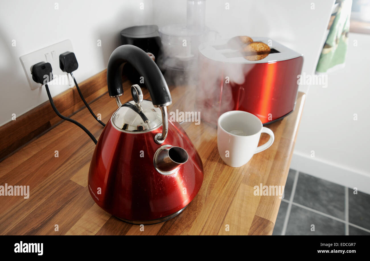 Wasserkocher Kochen mit Dampf und Toaster Toast hinter in eingesteckt Elektrogeräte Küche kochen Stockfoto