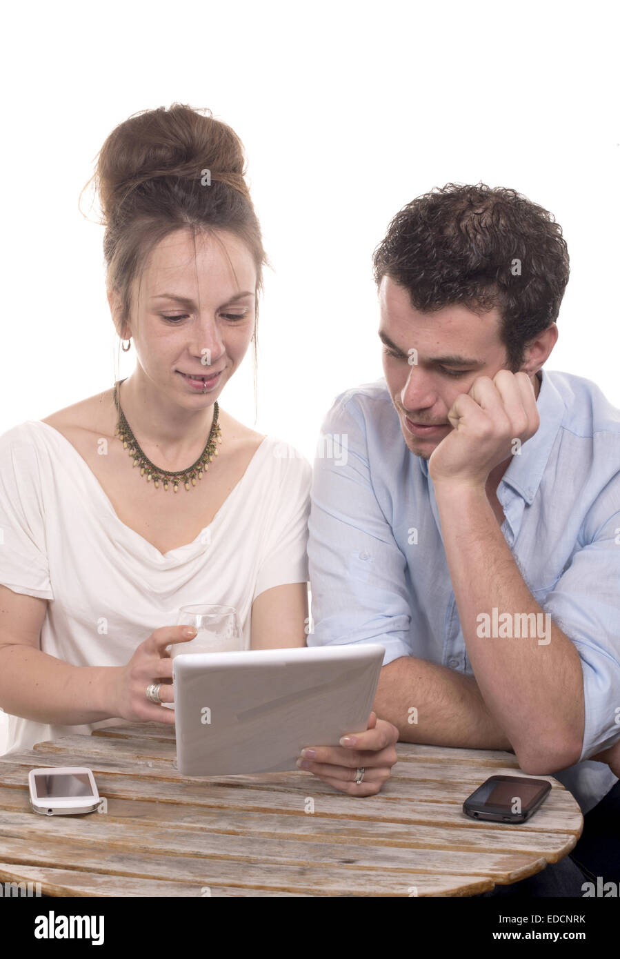 junges Paar mit Blick auf einen Tabletcomputer und lächelnd Stockfoto