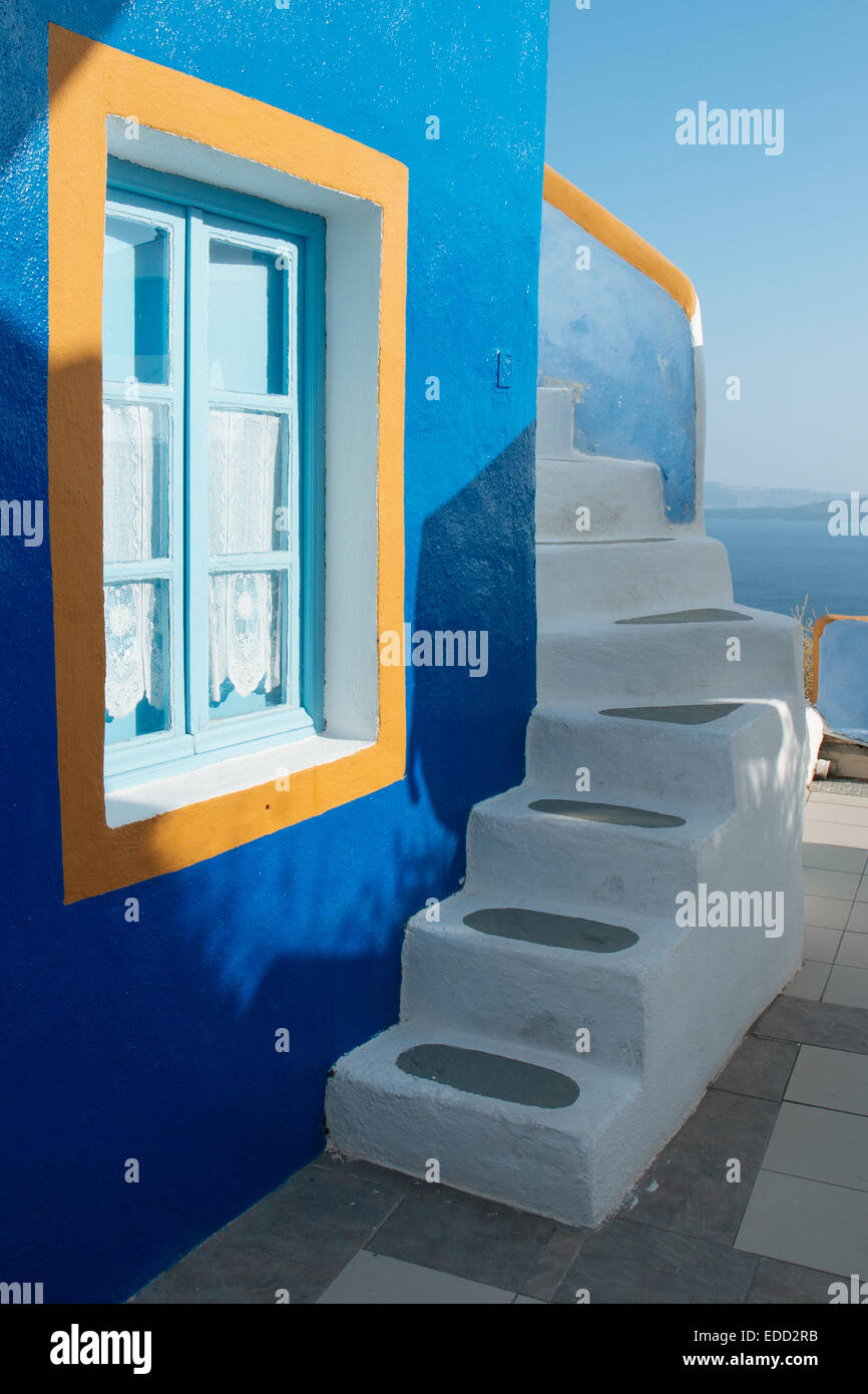 Blaue Wand mit Fenster und weiße Treppe in Oia, Santorini, Cyclades, griechische Inseln, Griechenland Stockfoto