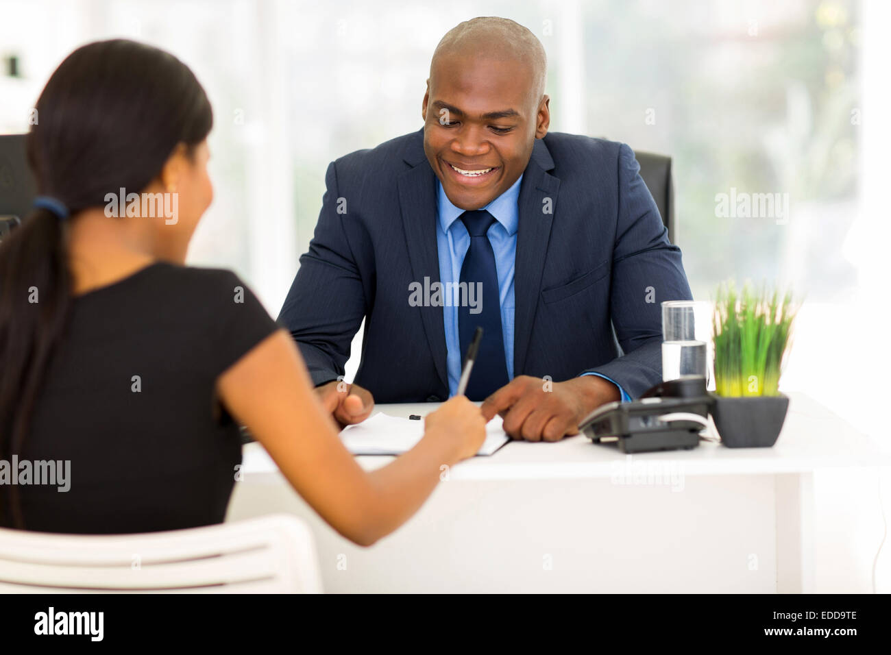 Rückansicht des Afrikanerin Unterzeichnung Arbeitsvertrag im Büro Stockfoto