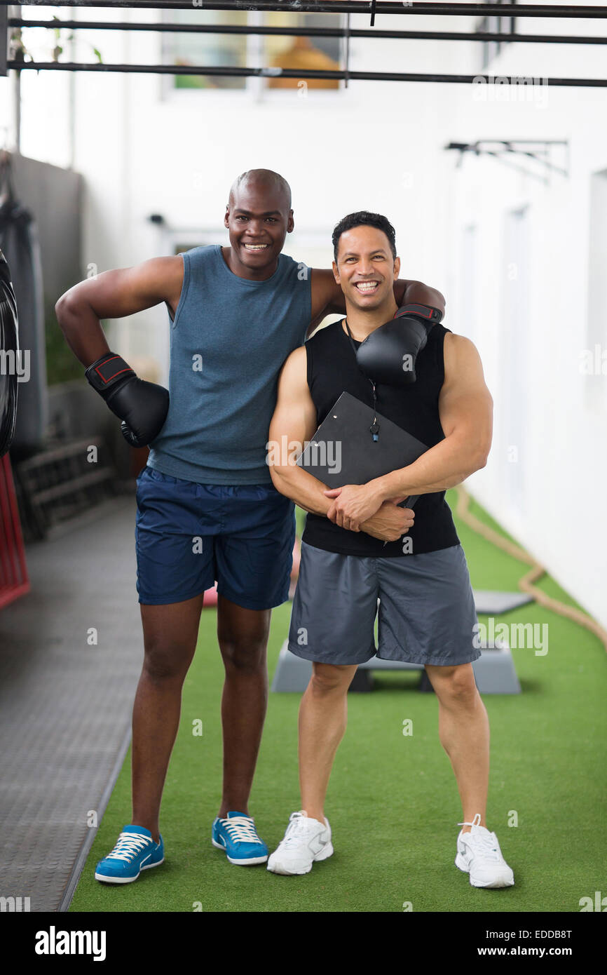 glückliche junge afrikanische Boxer mit seinem Trainer im Fitness-Studio Stockfoto
