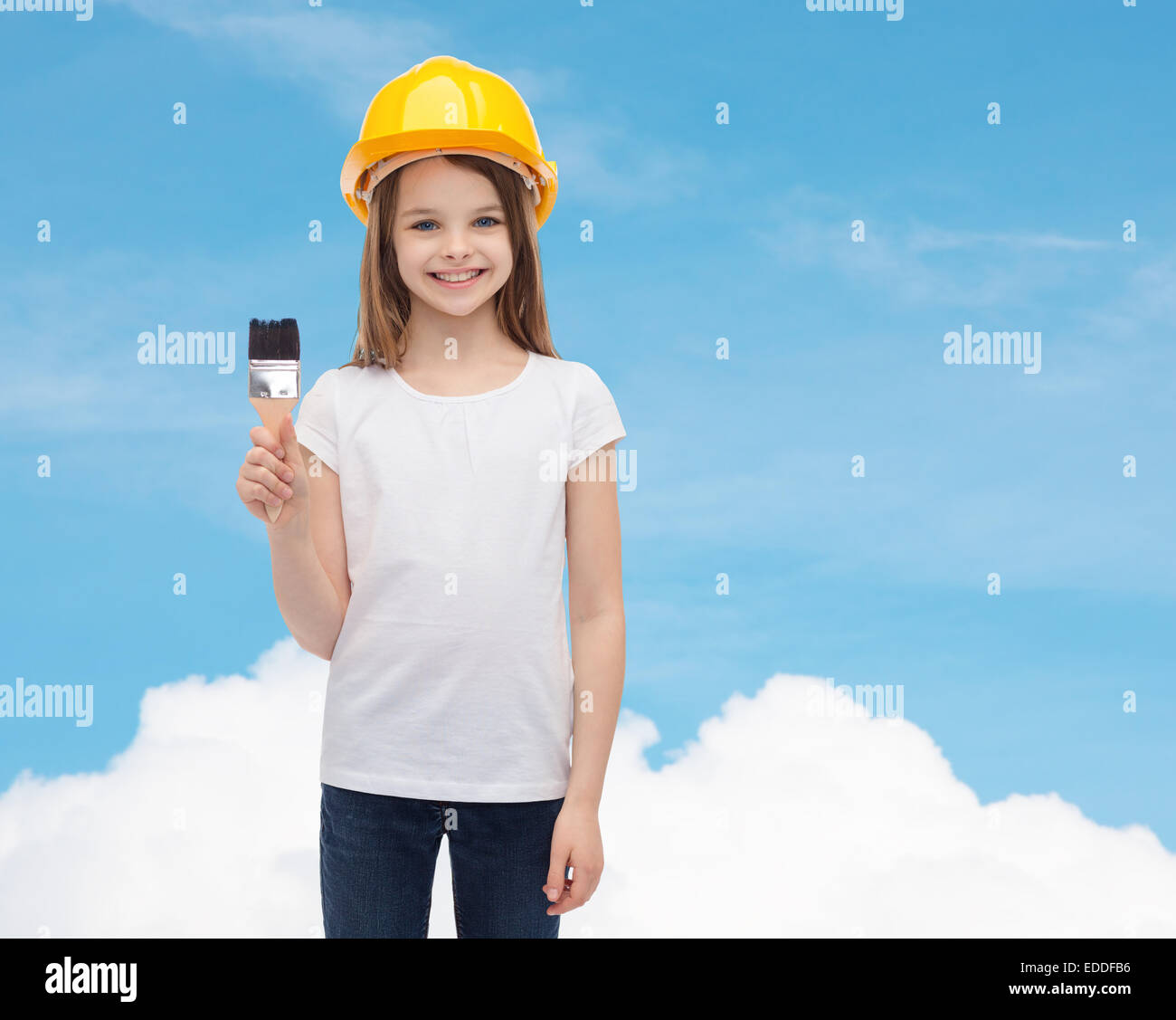 kleines Mädchen im Helm mit Farbroller lächelnd Stockfoto