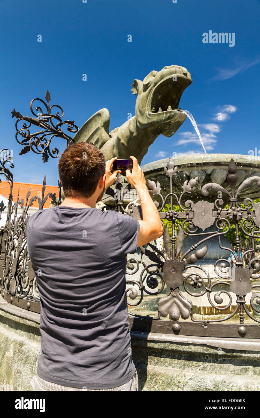 Österreich, Klagenfurt, Mann unter Bild Lindwurm-Brunnen Stockfoto