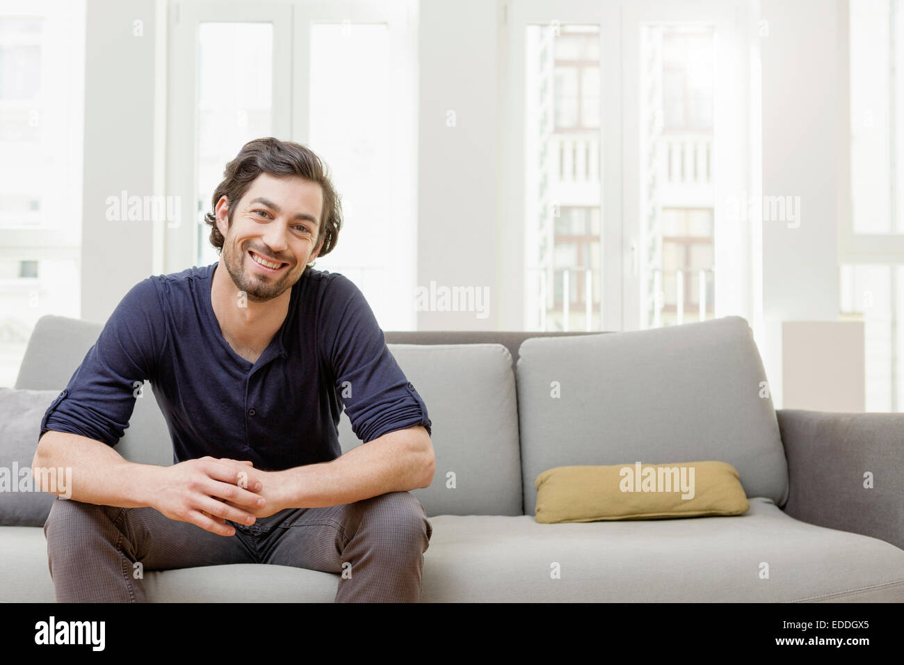 Lächelnder Mann auf sofa Stockfoto