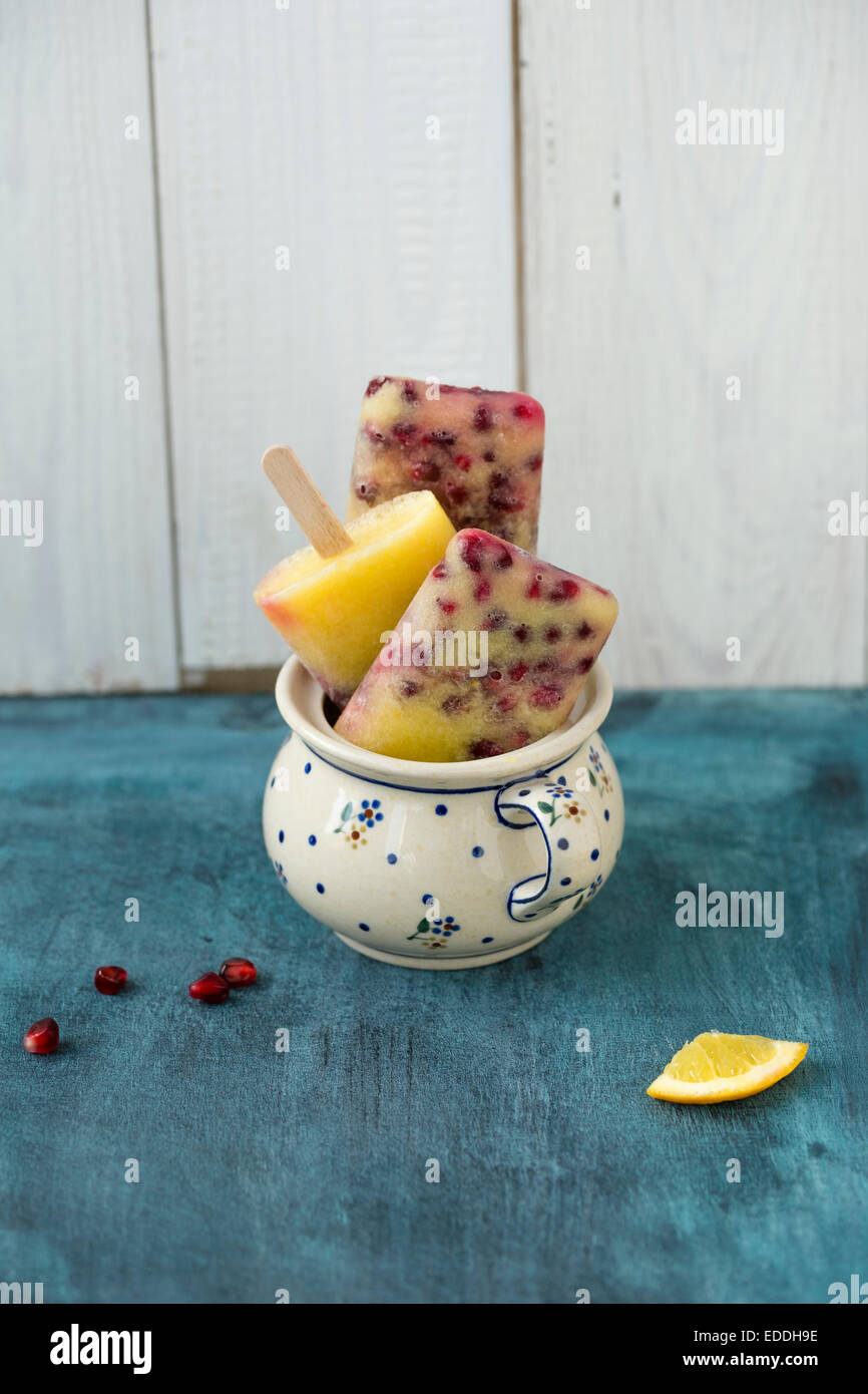 Glas mit drei orange-Granatapfel-Eis-Lutscher Stockfoto