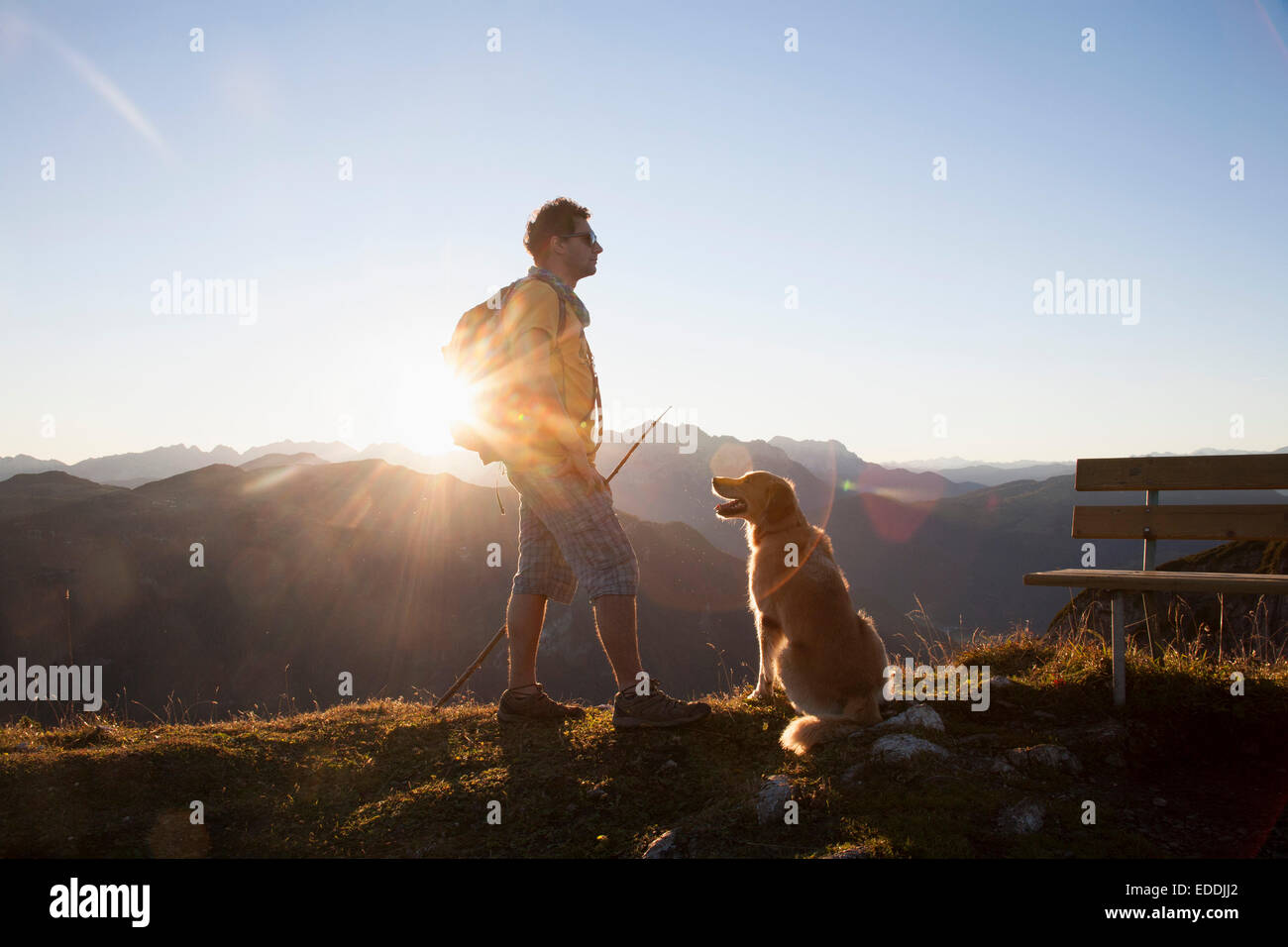 Österreich, Tirol, Unterberghorn, Wanderer mit Hund bei Sonnenaufgang Stockfoto